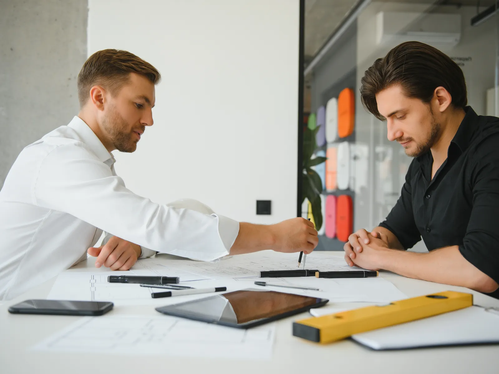 Zwei Ingenieure besprechen Pläne am Schreibtisch
